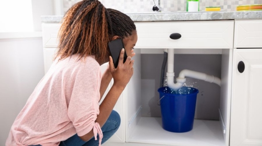 woman calling someone over leaking pipe